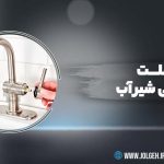 بنر گرافیکی با پس‌زمینه خاکستری تیره که در یک کادر دایره‌ای نمایی از تعمیر شیر آب (مانند image_16.png) را نشان می‌دهد. متن فارسی "علت نشتی شیر آب چیست؟" با فونت سفید درشت در سمت راست دیده می‌شود. لوگوی Jolgeh در بالا سمت چپ و اطلاعات تماس در پایین سمت راست قرار دارند.