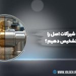 یک تصویر بنر با پس‌زمینه خاکستری تیره و نورپردازی ملایم. در سمت چپ، یک بزرگنمایی دایره‌ای وجود دارد که یک زانویی لوله را به دو صورت برنجی (سمت راست) و کروم (سمت چپ) نشان می‌دهد. در سمت راست دایره، متن فارسی "چگونه شیرآلات اصل را از تقلبی تشخیص دهیم؟" با فونت درشت سفید نوشته شده است. لوگوی Jolgeh در بالا سمت چپ و اطلاعات تماس (@JOLGEHGROUP و WWW.JOLGEH.IR) در پایین سمت راست قرار دارند. یک فلش سبز رنگ با نوارهای مورب در گوشه پایین سمت چپ دیده می‌شود.